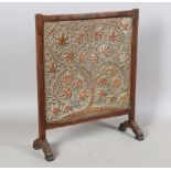 A late 19th century Arts and Crafts copper firescreen, the walnut frame supporting a pierced