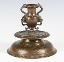 A 17th/18th century Italian brown patinated bronze candlestick, the urn shaped nozzle with twin