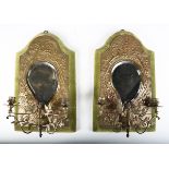 A pair of late Victorian Aesthetic Movement brass two-branch girandole wall mirrors, the bevelled