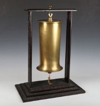 A First World War brass shell case, converted to a dinner gong, raised on a carved wooden stand,