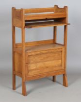 An Edwardian Arts and Crafts oak booktrough shelf, attributed to Wylie & Lockhead, the shaped