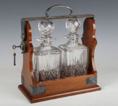 A 20th century silver plate mounted two-bottle tantalus with locking handle mechanism, stamped 'P.