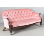 A good Victorian mahogany framed salon settee, upholstered in pink velour, the finely carved