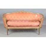An early 20th century Louis XVI style gilt showframe salon settee, upholstered in pink damask, on