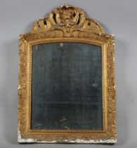 A late 18th century French gilt gesso wall mirror with foliate crest and distressed plate glass,