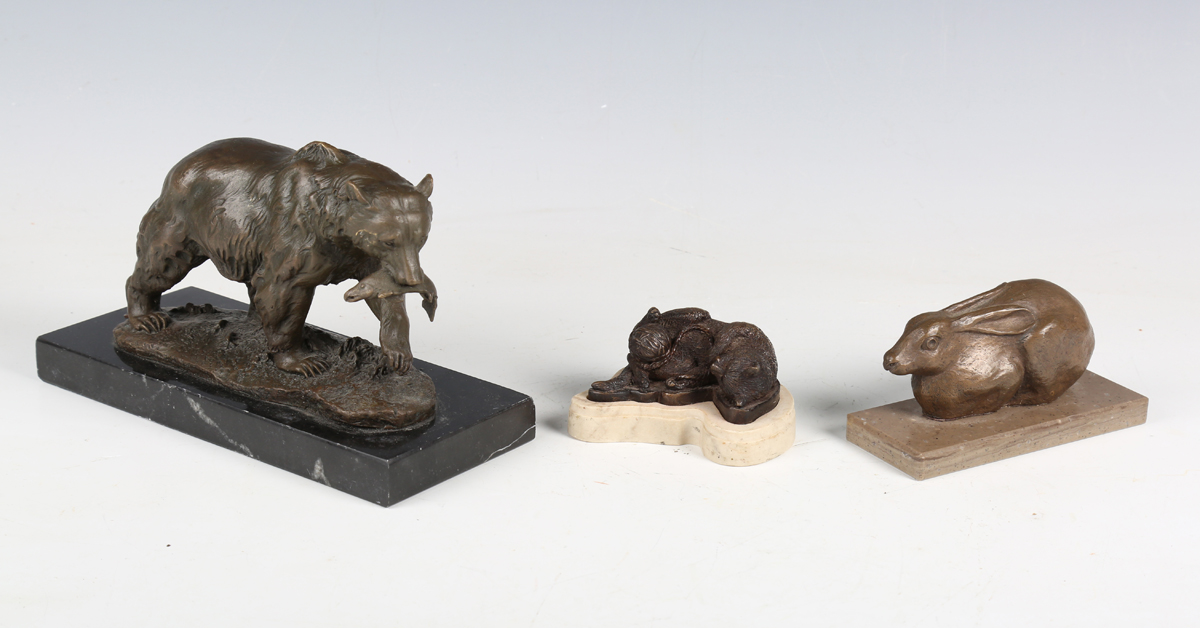 A late 20th century brown patinated cast bronze model of a bear with a fish in its mouth, on a black