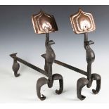 A pair of late 19th century Arts and Crafts wrought iron and copper mounted andirons, each of