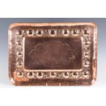 A late 19th/early 20th century Arts and Crafts Newlyn copper tray, the central shaped reserve within