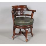 An early 20th century walnut revolving tub back desk chair, the circular seat upholstered in green