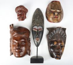 A late 20th century Balinese carved wooden wall mask, height 29cm, and four other ethnic wall