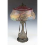 An early 20th century American Art Nouveau patinated cast metal and painted glass table lamp by