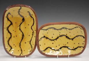 A pair of studio pottery slipware dishes, probably by Robin Welch, of oblong shape with wavy line