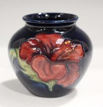 A Moorcroft Pottery Hibiscus pattern cobalt blue ground vase of bulbous shape, applied paper label