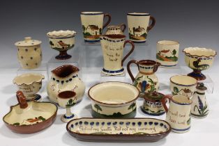 A large mixed group of Torquay motto ware pottery, including vases, jugs, plates, dishes and