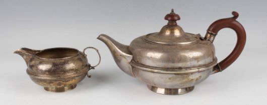 A George V silver teapot, presentation inscribed, and matching milk jug, of squat circular girdled