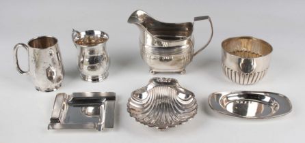 A George III silver cream jug of cushion form with reeded decoration, on ball feet, London 1810,