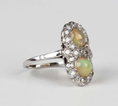 A white gold, opal and diamond ring, mounted with two circular cabochon opals within a surround of