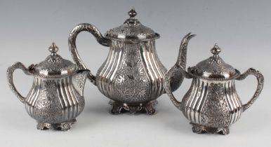 An Elizabeth II silver three-piece tea set of baluster form with panels of foliate stems between