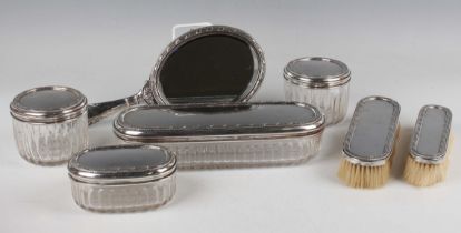 An early 20th century French silver dressing table set, decorated in relief with ribbon and reeded