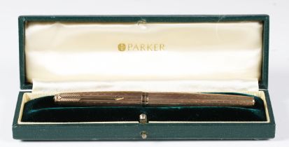 A 9ct gold cased Parker 61 fountain pen with engine turned decoration and engraved monogram,
