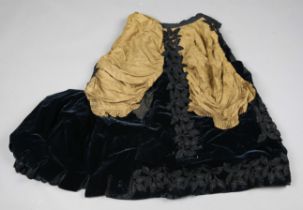 A late Victorian velvet and silk bustle skirt with applied beaded panels and train.Buyer’s Premium