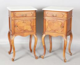 A pair of late 19th century French walnut bedside cabinets, each white marble top above a drawer and