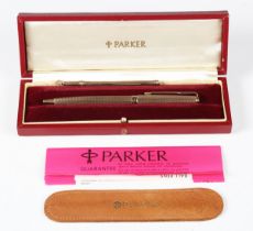 A 9ct gold cased Parker ballpoint pen with engine turned decoration and presentation inscription,