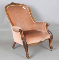 A Victorian walnut showframe salon armchair, carved with leaf and flower decoration, upholstered