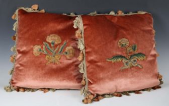 A pair of matching pink velvet cushions with applied 17th century floral slips and tasselled