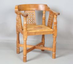 A mid-20th century Robert 'Mouseman' Thompson oak tub back armchair, the three lattice carved panels