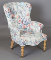 A modern Victorian style buttoned back armchair, upholstered in printed floral fabric, height