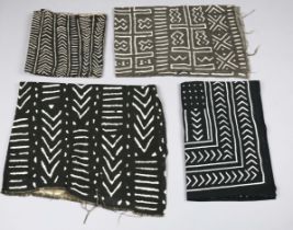 A group of African and ethnic textiles, including black and white printed mudcloth panels.Buyer’s
