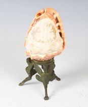 An early 20th century Neapolitan cameo carved conch shell, raised on a igris cast metal stand,