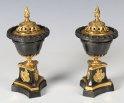 A pair of Regency black patinated and gilt bronze cassolettes of classical urn form, raised on