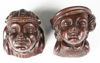 A pair of 19th century carved oak wall masks, one modelled wearing a mitre style hat, height 10cm.