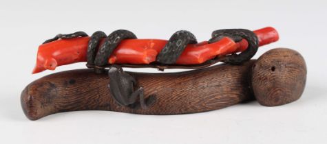 A Japanese carved wood, bronze and coral branch paperweight, Meiji period, the coral branch entwined