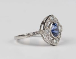 A platinum, sapphire and diamond ring, collet set with an oval mixed cut sapphire within an openwork