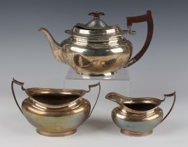 A George V silver three-piece tea set of oval form with egg and dart rims, comprising teapot, two-