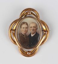 An Edwardian gold mounted brooch, glazed with a coloured photographic portrait of a lady and