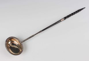 A George III silver punch ladle with twisted whalebone handle, the oval bowl with gadrooned rim,