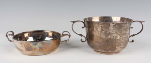An Edwardian silver circular porringer with flared rim, flanked by two scroll handles, on a circular