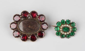 A Georgian foil-backed flat cut garnet oval brooch, glazed with a hair locket compartment within a