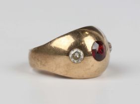 A gold, garnet and diamond ring, gypsy set with a cushion cut garnet between two variously cut