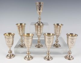 A set of eight George V silver kiddush cups, each tapering cylindrical bowl engraved with Star of