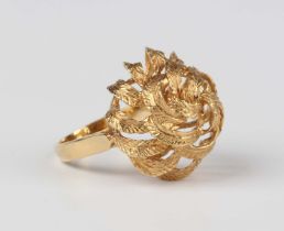 A gold ring with cast foliate decoration, detailed '750', weight 7.2g, ring size approx L.Buyer’s