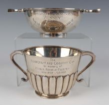 A late Victorian silver two-handled cup of tapering cylindrical half-reeded form, the front