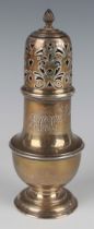 A George V silver baluster sugar caster with scroll pierced domed cover and spiral finial, on a