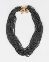 A multiple row collar necklace of hematite beads on an 18ct gold and diamond set clasp, designed