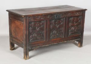 An early 18th century oak panelled coffer with original hinges and carved front, height 70cm,