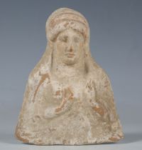 A Hellenistic terracotta plaque, circa 300 BC, modelled as a half-length female, her hands